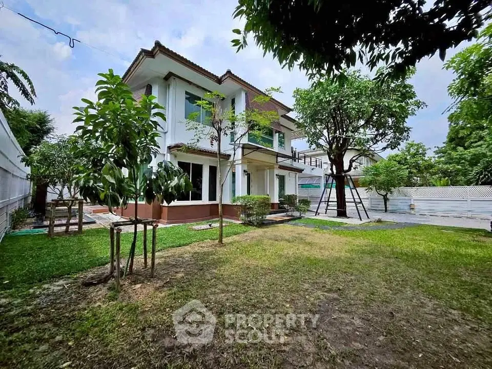Charming two-story home with lush garden and spacious yard, perfect for family living.