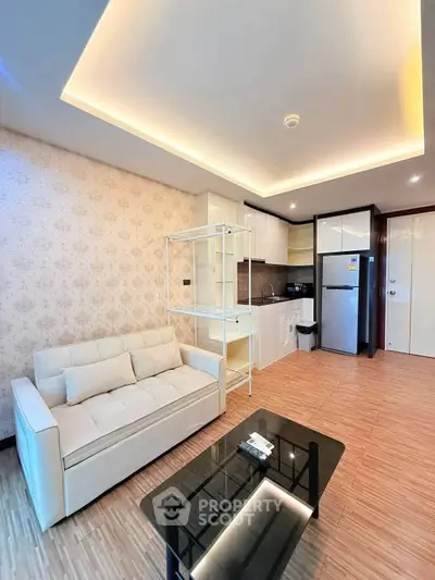 Modern living room with open kitchen, stylish lighting, and elegant decor in a cozy apartment.