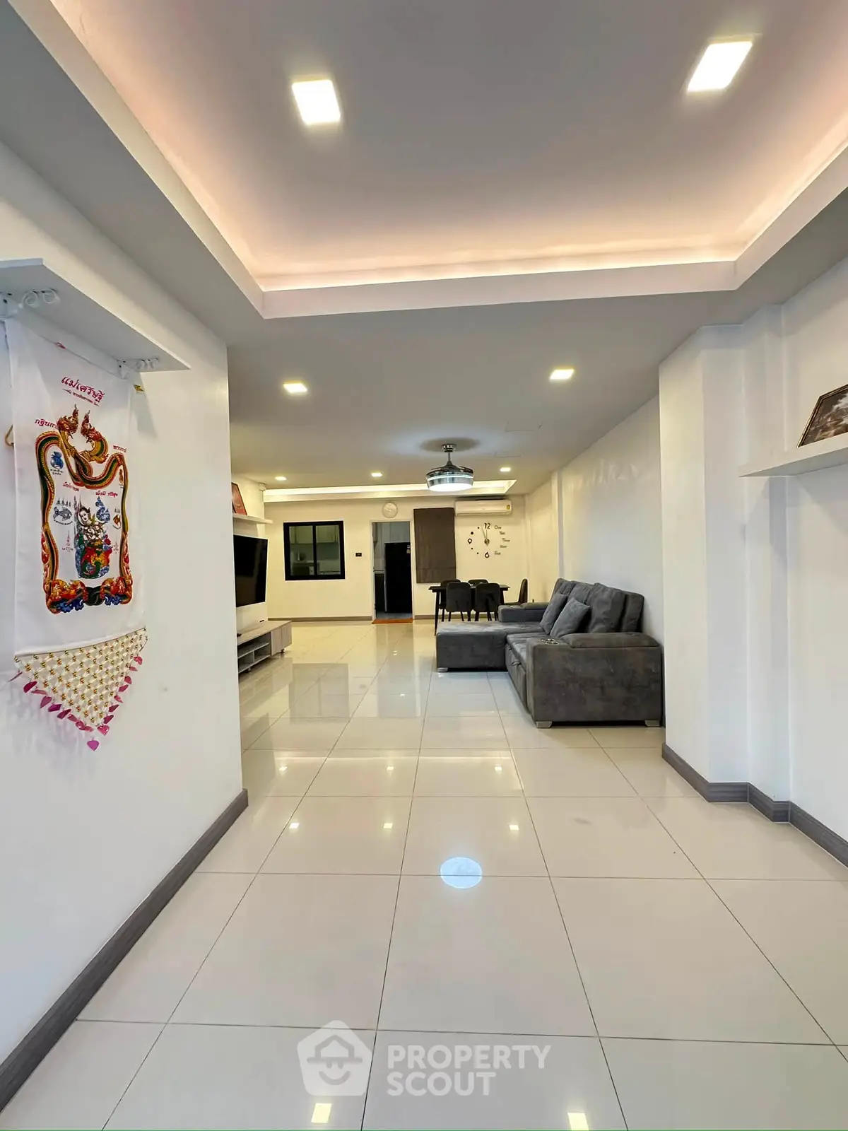 Spacious modern living room with sleek tile flooring and cozy seating area.