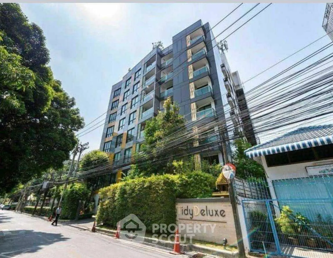 Modern apartment building with lush greenery and clear blue sky