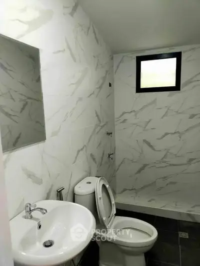 Modern bathroom with marble tiles and compact design