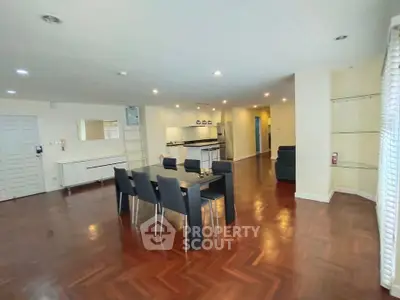 Spacious open-plan living and dining area with modern furnishings and hardwood floors.