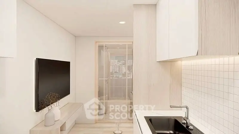 Modern kitchen with sleek design and integrated living area, featuring a large TV and stylish decor.