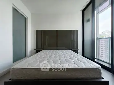Spacious bedroom with large windows and modern wardrobe, offering ample natural light and city views.