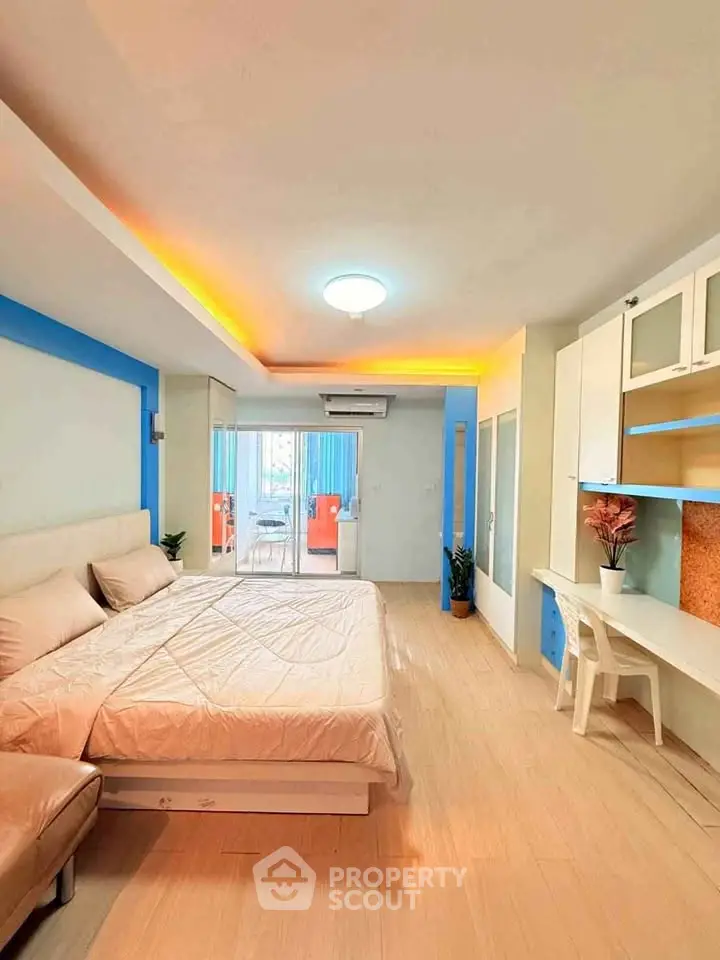 Spacious bedroom with modern decor and balcony access in a vibrant apartment.