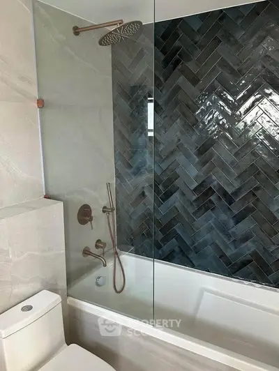 Modern bathroom with elegant herringbone tile and rainfall showerhead