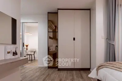 Modern bedroom with stylish wardrobe and elegant decor, featuring a glimpse into a cozy study area.