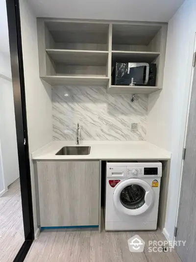 Modern compact kitchen with washing machine and marble backsplash