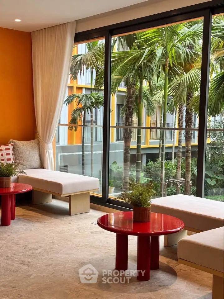 Stylish living room with large windows and garden view, featuring modern furniture and vibrant decor.