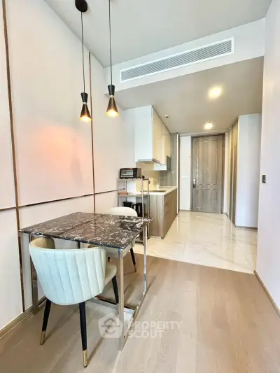 Modern kitchen with marble dining table and elegant lighting in a stylish apartment.