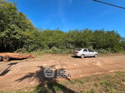 Vacant land with lush greenery and clear blue sky, ideal for development opportunities.