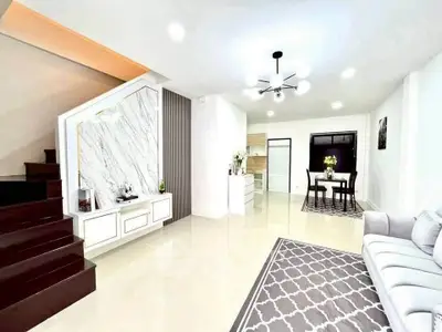 Spacious modern living room with elegant dining area and stylish staircase
