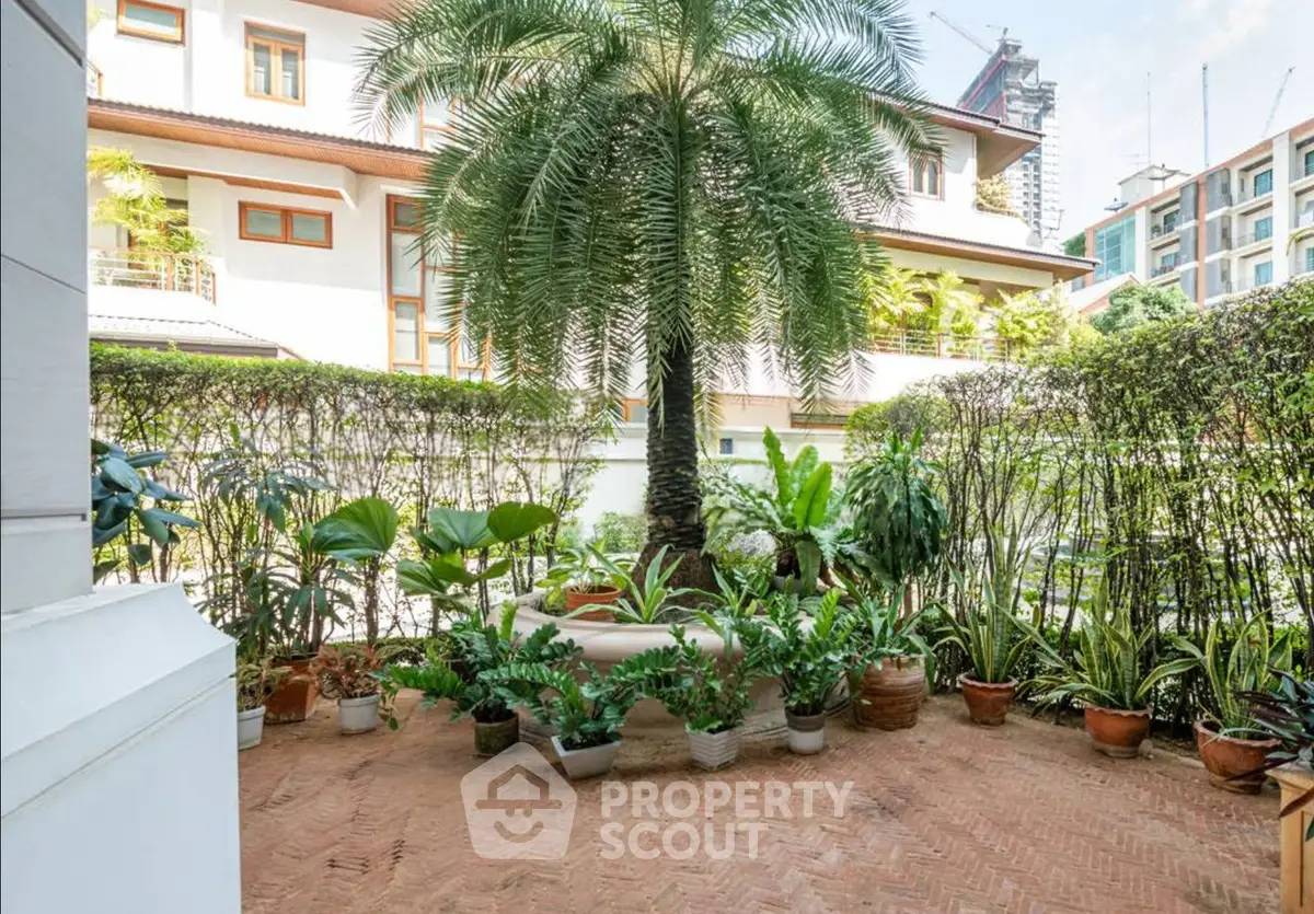 Charming garden oasis with lush greenery and potted plants in a serene residential setting.