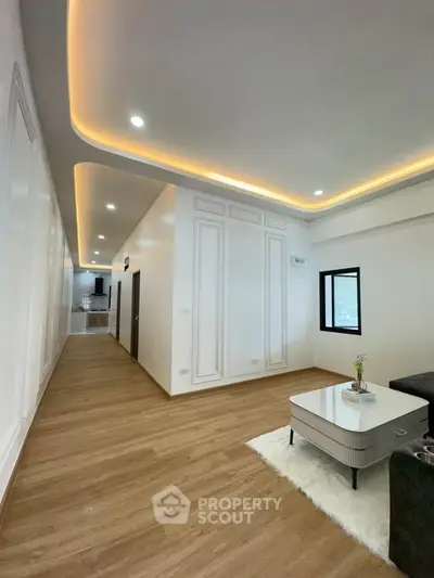 Spacious modern living room with elegant ceiling lights and wooden flooring