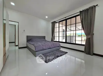 Spacious bedroom with large windows and modern decor