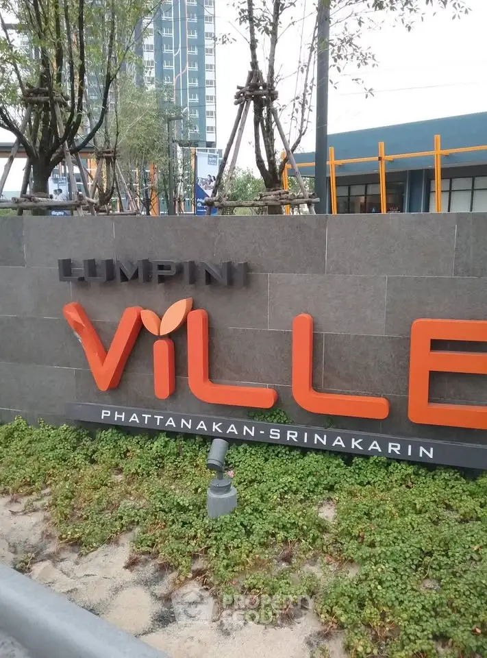 Modern entrance sign of Lumpini Ville Phatthanakan-Srinakarin with lush greenery.