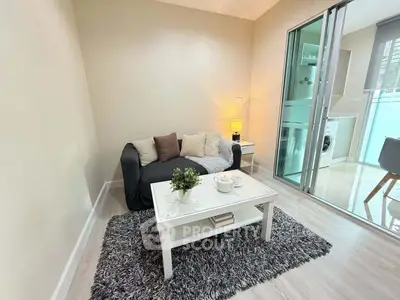 Cozy living room with modern decor and balcony access, featuring a plush sofa and stylish coffee table.