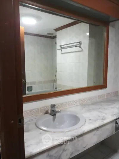 Spacious bathroom with marble countertop and large mirror