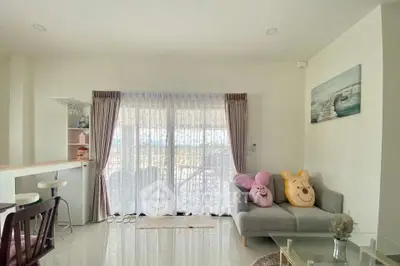 Bright living room with cozy sofa and balcony view, perfect for relaxation.