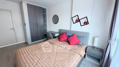 Modern bedroom with stylish decor, featuring a cozy bed, sleek wardrobe, and natural light from large windows.