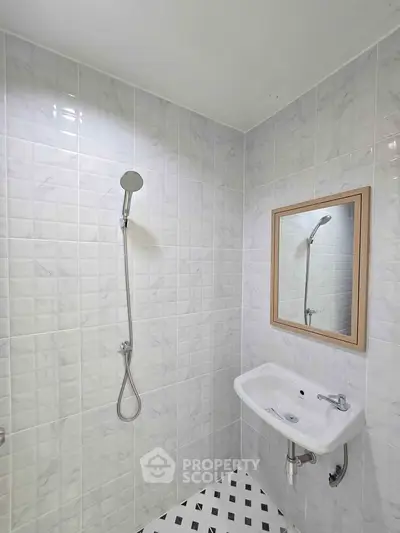 Modern bathroom with sleek shower and stylish sink in tiled interior.