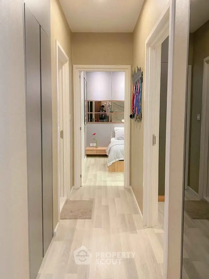 Modern hallway leading to a cozy bedroom with stylish decor and soft lighting.