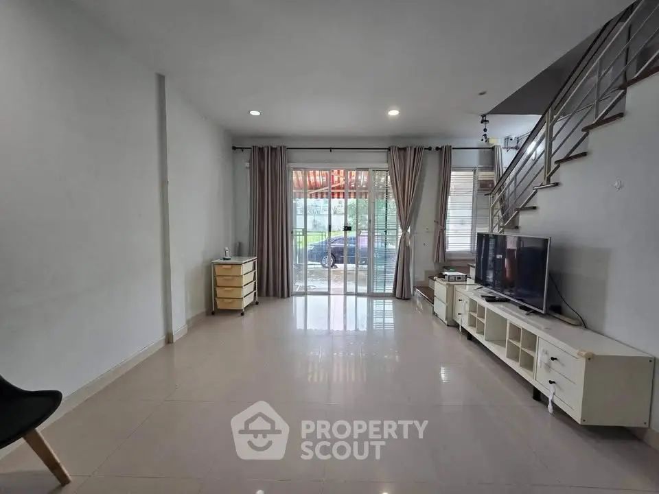 Spacious living room with modern decor and large windows for natural light.