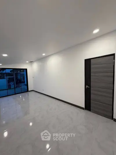 Spacious modern living room with sleek flooring and large windows for natural light.