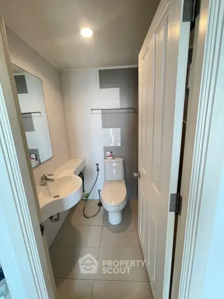 Modern bathroom with sleek fixtures and minimalist design, featuring a wall-mounted sink and contemporary toilet.