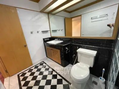 Spacious bathroom with elegant black and white tile design and modern fixtures.