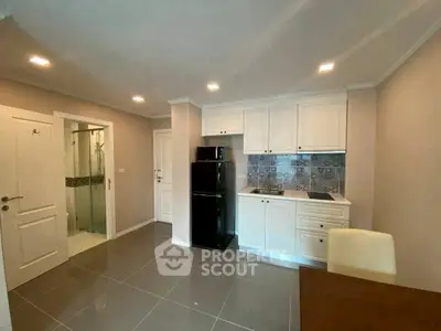 Modern kitchen with sleek white cabinets and stylish backsplash in a cozy apartment.