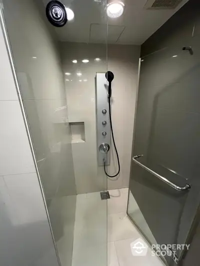 Modern shower with glass door and sleek fixtures in contemporary bathroom.