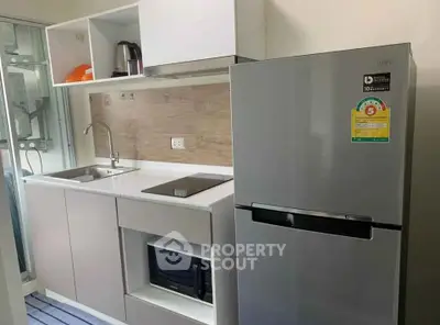 Modern kitchen with sleek appliances and stylish cabinetry in a compact layout.