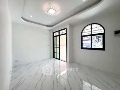 Spacious modern living room with marble flooring and large windows for natural light.