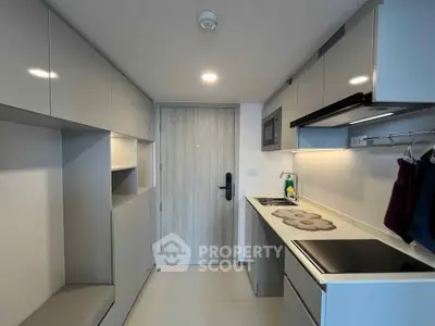 Modern compact kitchen with sleek cabinetry and built-in appliances in a contemporary apartment.