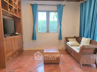 Charming living room with wooden furniture and blue curtains, perfect for cozy relaxation.