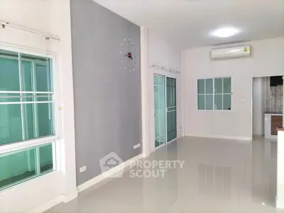 Spacious modern living room with large windows and sleek tile flooring