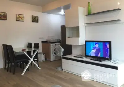 Modern living room with dining area and TV, featuring sleek furniture and wooden flooring.