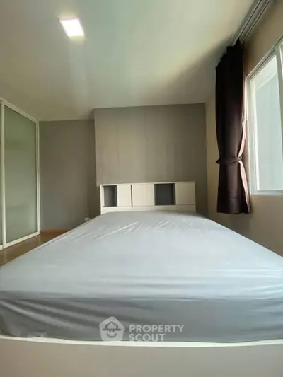 Spacious bedroom with large window and modern design, perfect for natural light lovers.