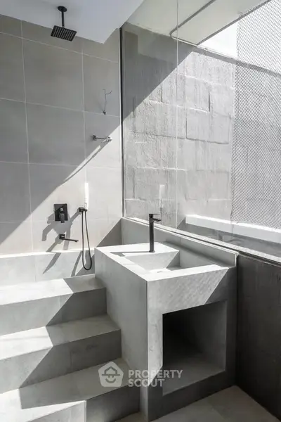 Modern minimalist bathroom with sleek concrete design and open shower concept.