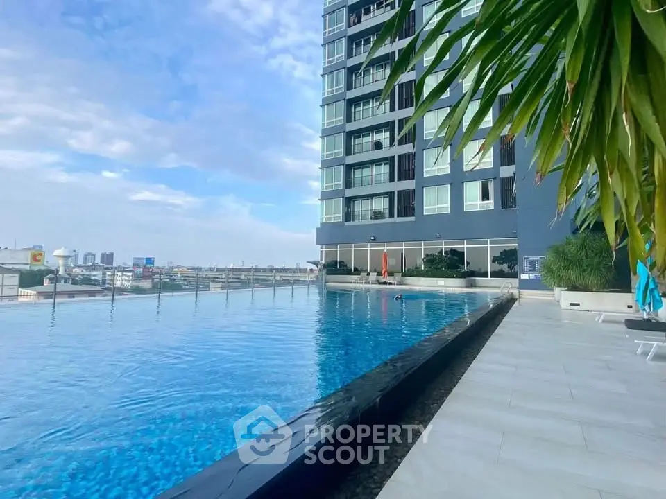 Luxurious high-rise building with stunning rooftop pool and city view, perfect for urban living.