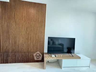 Modern living room with sleek TV setup and wooden accent wall