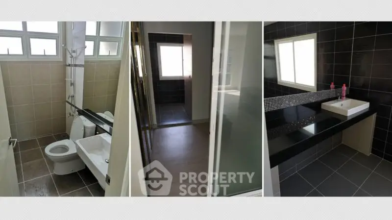 Modern bathroom with sleek black tiles and large windows for natural light.