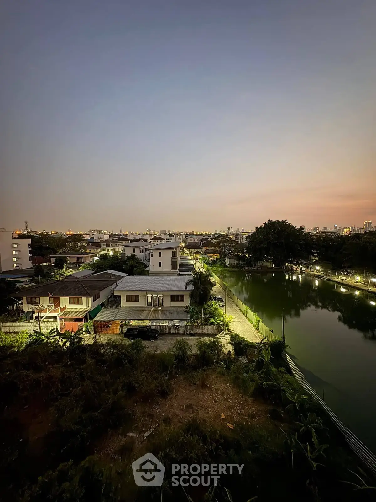 Stunning evening view of suburban homes by a serene lake, perfect for tranquil living.