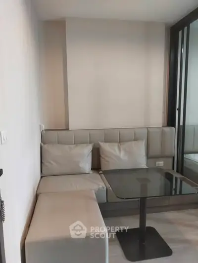 Cozy modern living room with sleek furniture and glass table