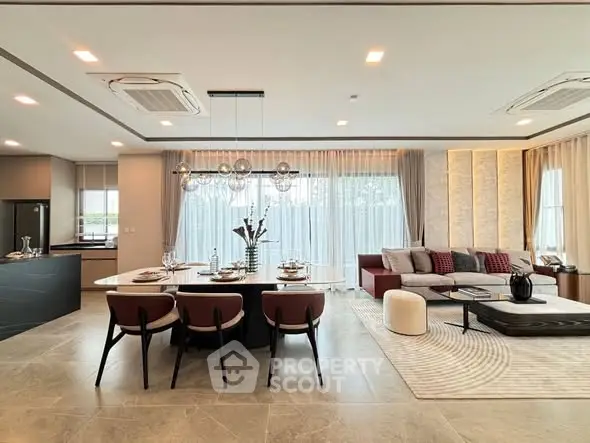 Luxurious open-plan living and dining area with modern decor and ample natural light.