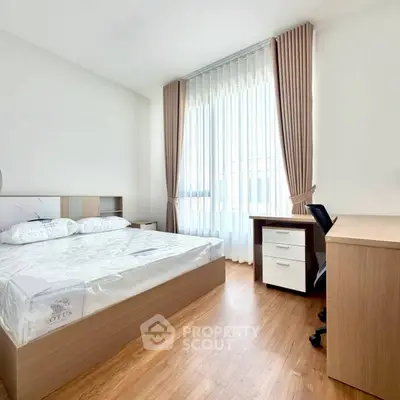 Bright and modern bedroom with wooden flooring and study desk