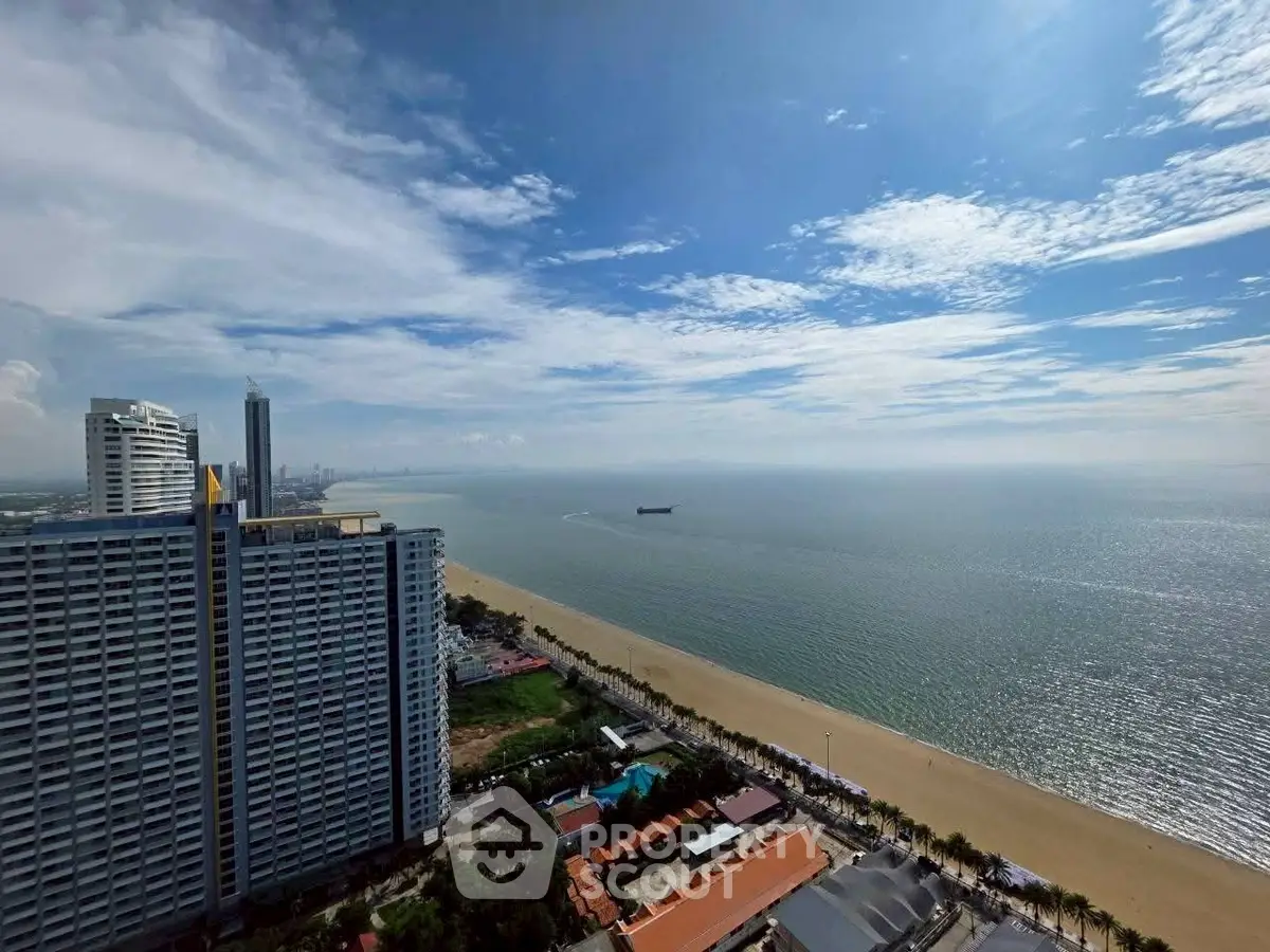 Stunning beachfront view from high-rise building overlooking ocean and city skyline.
