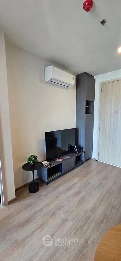 Modern living room with sleek TV stand and air conditioning unit, perfect for cozy entertainment.