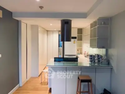 Modern kitchen with sleek design and open layout, featuring a central island and stainless steel appliances.